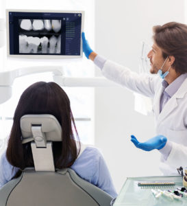 dentist showing patient overjet xray and software